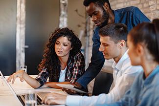 Business professionals reviewing work at computer